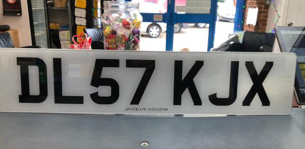 A standard plate that reads 'DL57 KJX'